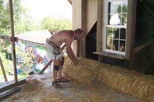 Kurt starts stacking them bales